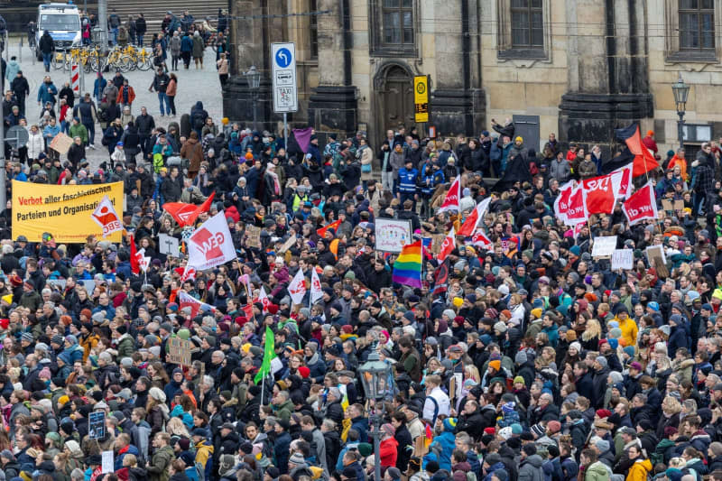 People take part in a demonstration of the Dresden action alliance "Wir sind die Brandmauer Dresden" on the theater square of the Saxon state capital against right-wing extremist activities. Daniel Schäfer/dpa