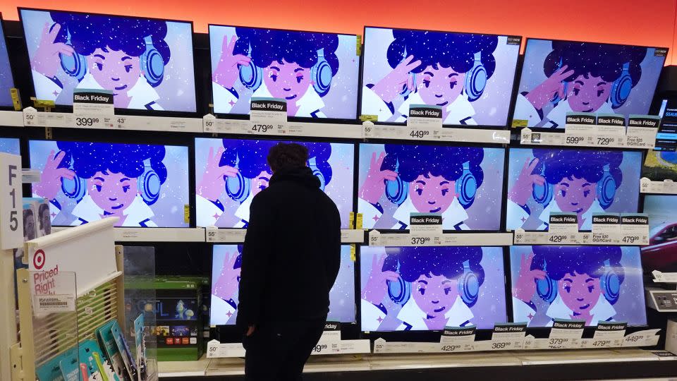 A shopper looks at televisions in a store in Indianapolis on Friday, Nov. 26, 2021. - Darron Cummings/AP