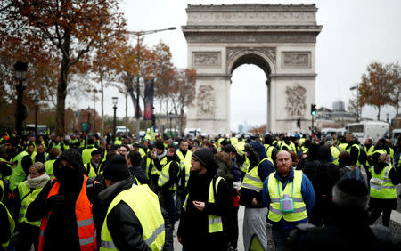 Protesters wearing yellow vests, a symbol of a French drivers' protest against higher fuel prices, block the Champs-Elysee in Paris, France, November 24, 2018. REUTERS/Benoit Tessier