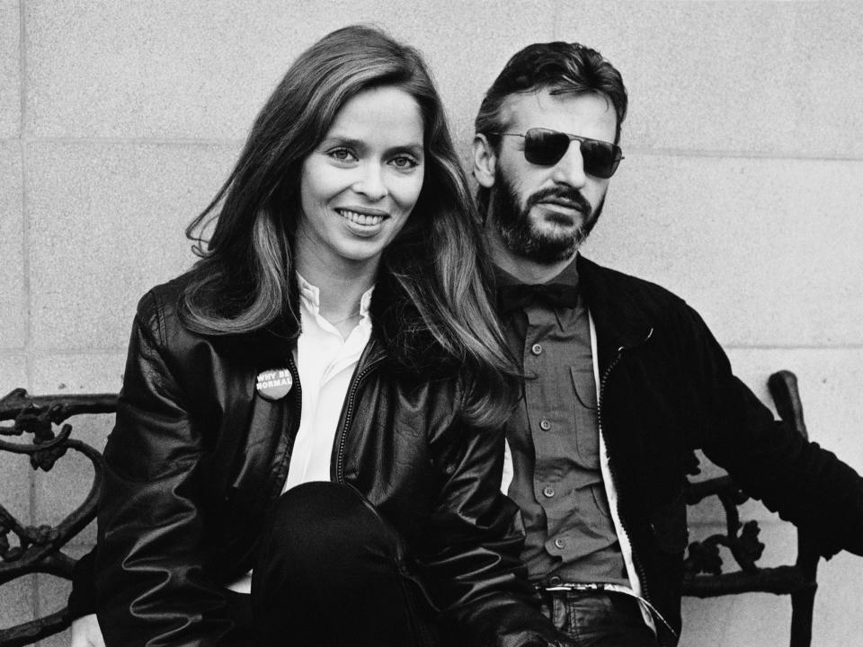 Black and white photo of Barbara and Ringo in jackets sitting on a bench.