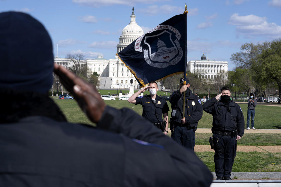 With the U.S. Capitol in the background, a U.S. Capitol Police officer salutes as procession carries the remains of a U.S. Capitol Police officer who was killed after a man rammed a car into two officers at a barricade outside the Capitol in Washington, Friday, April 2, 2021. (AP Photo/Jose Luis Magana)