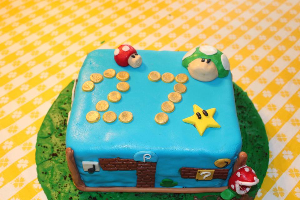 This undated photo provided by Justin Clark shows a Mario Brothers-themed square cake Clark made in Dallas. Clark, an amateur baker, typically uses a layer of fondant to cover a simple round cake, and gets creative from there. Shows like Ace of Cakes, Cake Boss, and various spinoffs tempt viewers with stunning visions of creations closer to art than dessert. This is the era of 3-D baking, and the simple, square birthday cake is little more than a remnant of the past. (AP Photo/Justin Clark)