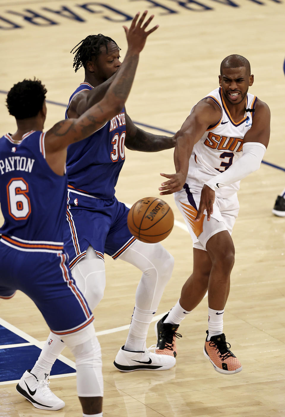 Phoenix Suns' Chris Paul (3) passes the ball as New York Knicks' Julius Randle (30) and Elfrid Payton (6) defend in the third quarter of an NBA basketball game Monday, April 26, 2021, in New York. (Elsa/Pool Photo via AP)