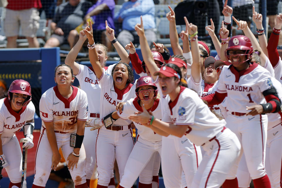 Oklahoma players cheer for Tiare Jennings, not pictured, at home plate after Jennings hit a 3-run home run against Tennessee during the second inning of an NCAA softball Women's College World Series game Saturday, June 3, 2023, in Oklahoma City. (AP Photo/Nate Billings)