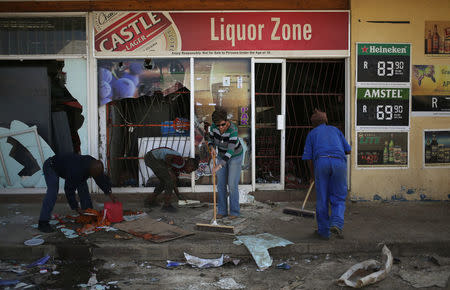 Locals clean up after over-night looting, when protesters took to the streets to demonstrate the killing of a boy in Coligny, North West province, South Africa, April 26, 2017. REUTERS/Siphiwe Sibeko