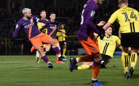 Manchester City's Argentinian striker Sergio Aguero (L) scores the opening goal during the English League Cup second leg semi-final football match between Burton Albion and Manchester City - Credit: &nbsp;Paul ELLIS/AFP