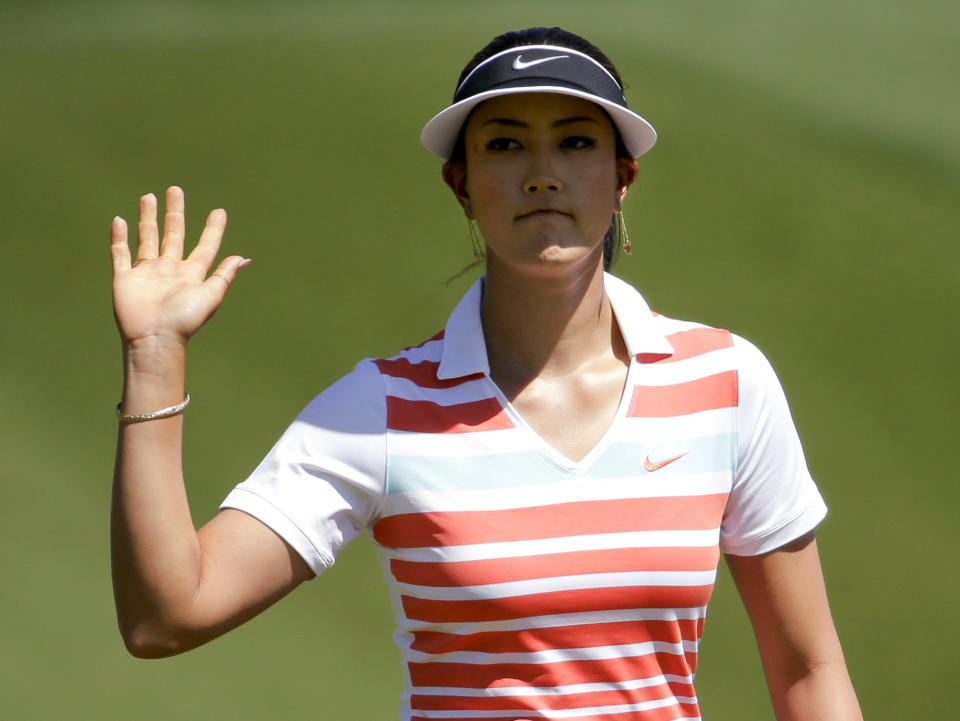 Michelle Wie waves after a birdie on the first hole during the third round of the Kraft Nabisco Championship golf tournament Saturday, April 5, 2014, in Rancho Mirage, Calif. (AP Photo/Chris Carlson)