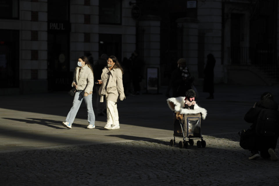 A person photographs their dog near St Paul's Cathedral in the City of London financial district of London, Friday, Jan. 22, 2021, during England's third national lockdown since the coronavirus outbreak began. The U.K. is under an indefinite national lockdown to curb the spread of the new variant, with nonessential shops, gyms and hairdressers closed, most people working from home and schools largely offering remote learning. (AP Photo/Matt Dunham)