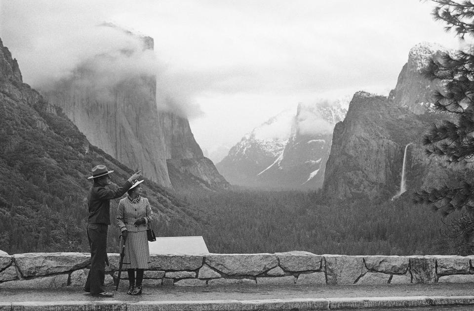 FILE - Park superintendent Bob Binnewies points out highlights from Inspiration Point to Queen Elizabeth II during her visit on Saturday, March 5, 1983 in Yosemite National Park, in California. The FBI has disclosed a potential threat to the late Queen Elizabeth during her 1983 trip to the U.S. West Coast. The documents were released this last week of May, 2023, on the FBI’s records website. (AP Photo/Walt Zeboski, File)