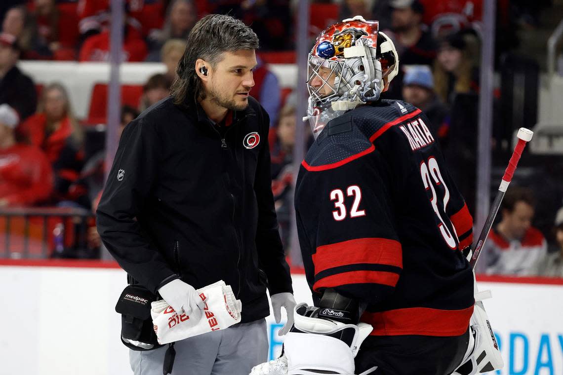Carolina Hurricanes head athletic trainer Doug Bennett, left, speaks with goaltender Antti Raanta, who sustained a collision during the first period of the team’s NHL hockey game against the Florida Panthers in Raleigh, N.C., Friday, Dec. 30, 2022. (AP Photo/Karl B DeBlaker)