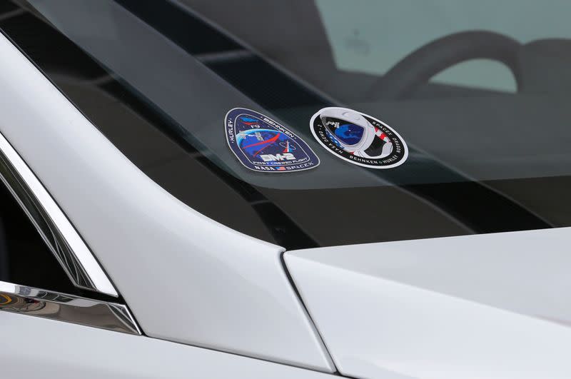 NASA astronauts Douglas Hurley and Robert Behnken place decals on their crew car at the Kennedy Space Center