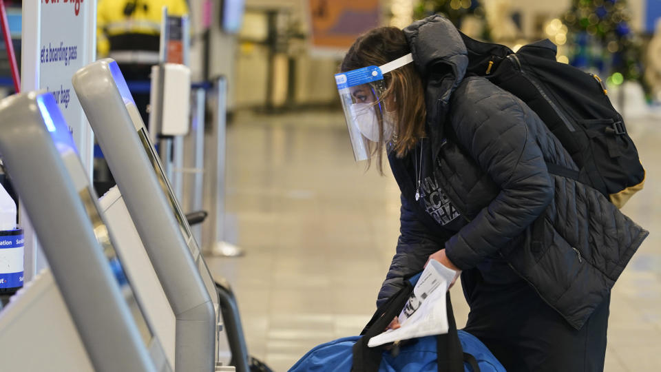 A traveler checks in before boarding a flight at Cleveland Hopkins International Airport, Wednesday, Nov. 25, 2020, in Cleveland. (AP Photo/Tony Dejak)