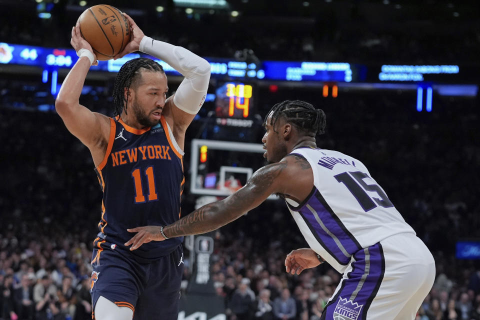 New York Knicks' Jalen Brunson (11) protects the ball from Sacramento Kings' Davion Mitchell (15) during the first half of an NBA basketball game Thursday, April 4, 2024, in New York. (AP Photo/Frank Franklin II)