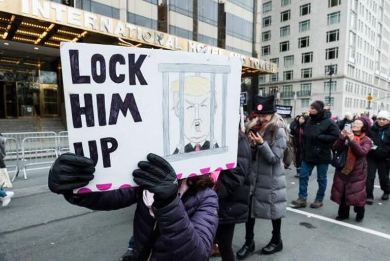 “Enciérrenlo”, dice el letrero que sostiene una mujer en una manifestación frente a la torre Trump de Manhattan.