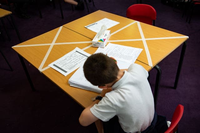 Child sat on a socially distanced table in a classroom