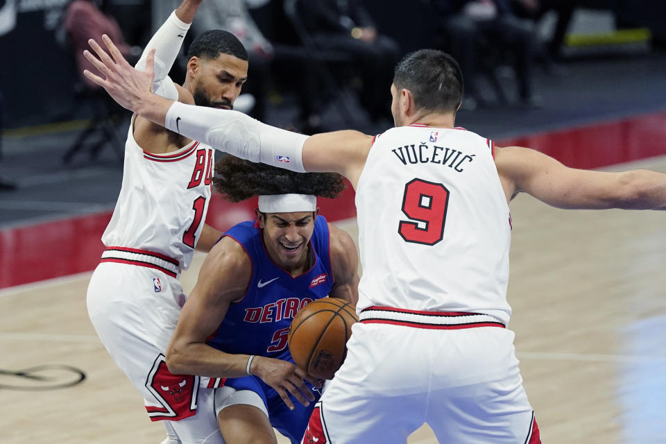 Detroit Pistons guard Frank Jackson (5) is defended by Chicago Bulls forward Garrett Temple (17) and center Nikola Vucevic (9) during the first half of an NBA basketball game, Sunday, May 9, 2021, in Detroit. (AP Photo/Carlos Osorio)