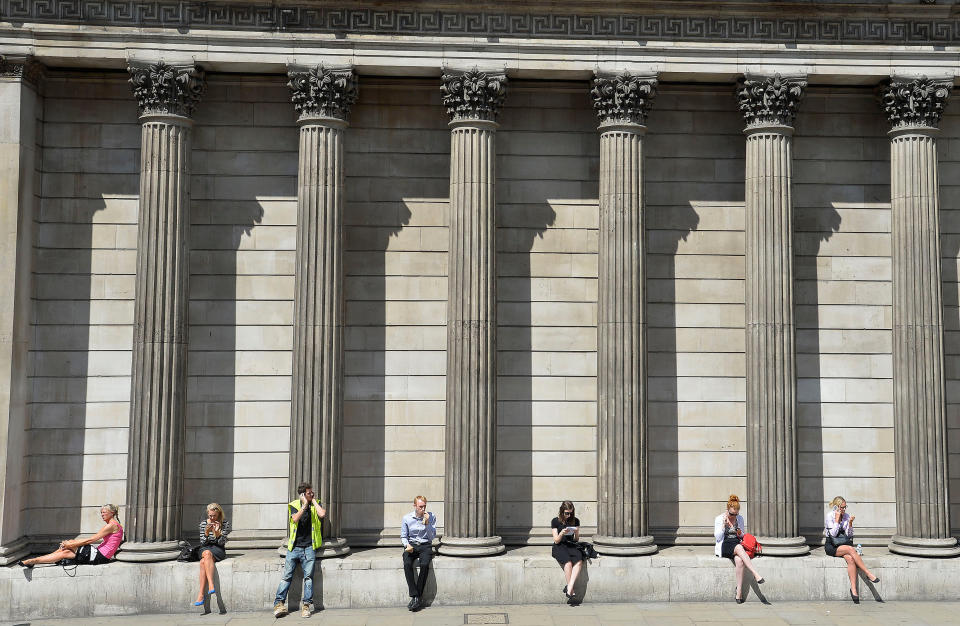 Workers relax during the lunch hour outside the Bank of England in the City of London. Photo: REUTERS/Toby Melville/File Photo