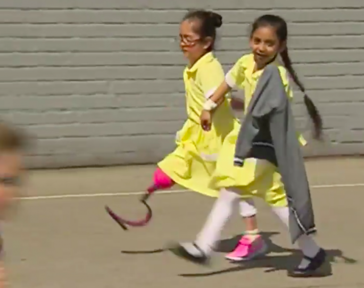 One little girl walked hand in hand with Anu around the school playground (BBC)