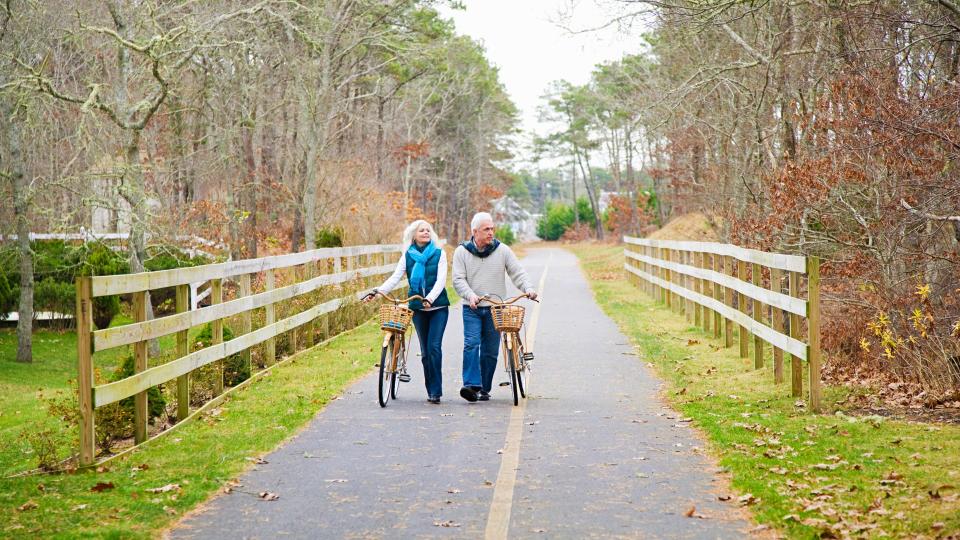 55 to 59 years, 60 to 64 years, Autumn, Bicycle, Cape Cod, Caucasian, Cycling, Female, Fence, Full Length, Healthy lifestyle, Horizontal, MAN, Male, Massachusetts, Mature Couple, Outdoors, Photography, Retirement, Tree, chatham, color, cross-media, cycle path, day, heterosexual couple, leisure, mature man, path, rural, senior woman, togetherness, two people, vacation, walking, winter, woman