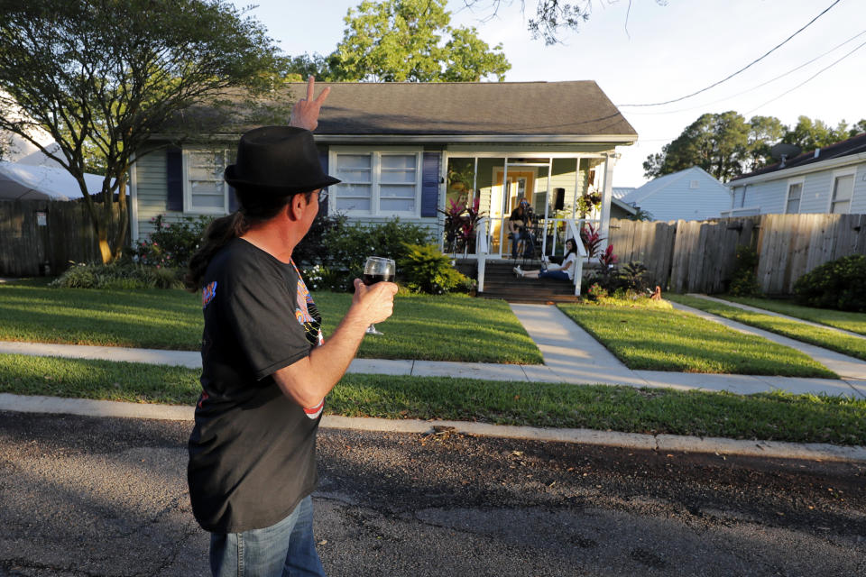 Dave Wilbert reacts as his neighbor Adam Pearce performs a concert from his front porch in New Orleans. (AP Photo/Gerald Herbert)