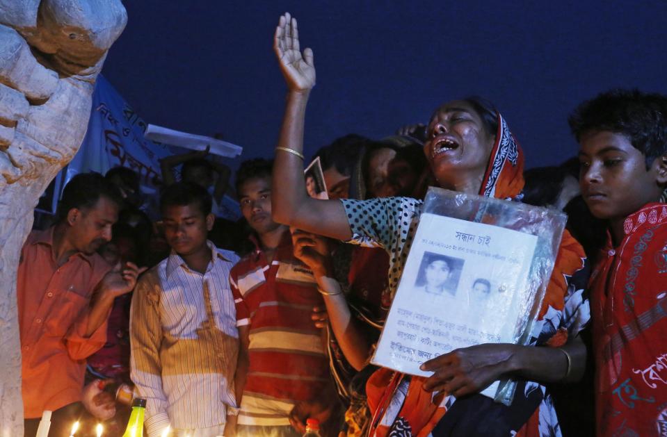 A Bangladeshi relative of a victim of last year’s Rana Plaza building collapse cries in front of a monument erected in memory of the victims, during a gathering on the eve of the tragedy in Savar, near Dhaka, Bangladesh, Wednesday, April 23, 2014. More than 1,100 people were killed when the illegally constructed, 8-storey building collapsed on April 24, 2013, in a heap along with thousands of workers in the five garment factories in the building. Placard reads “Farzana, Rana Plaza missing.” (AP Photo/A.M. Ahad)