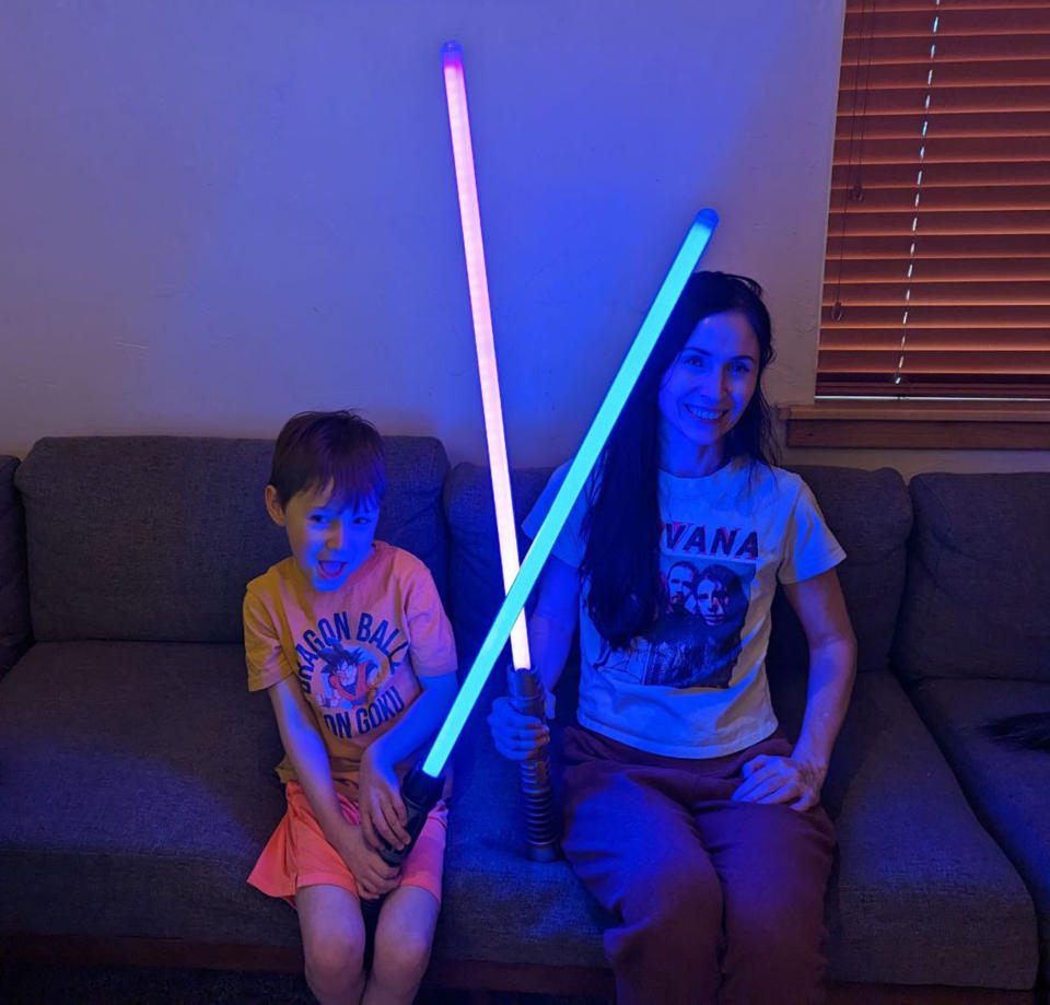 Casey Andrews and her son, showing off their lightsabers. Andrews says her house is more into video games than sports, and she's OK with that. (Courtesy Casey Andrews)