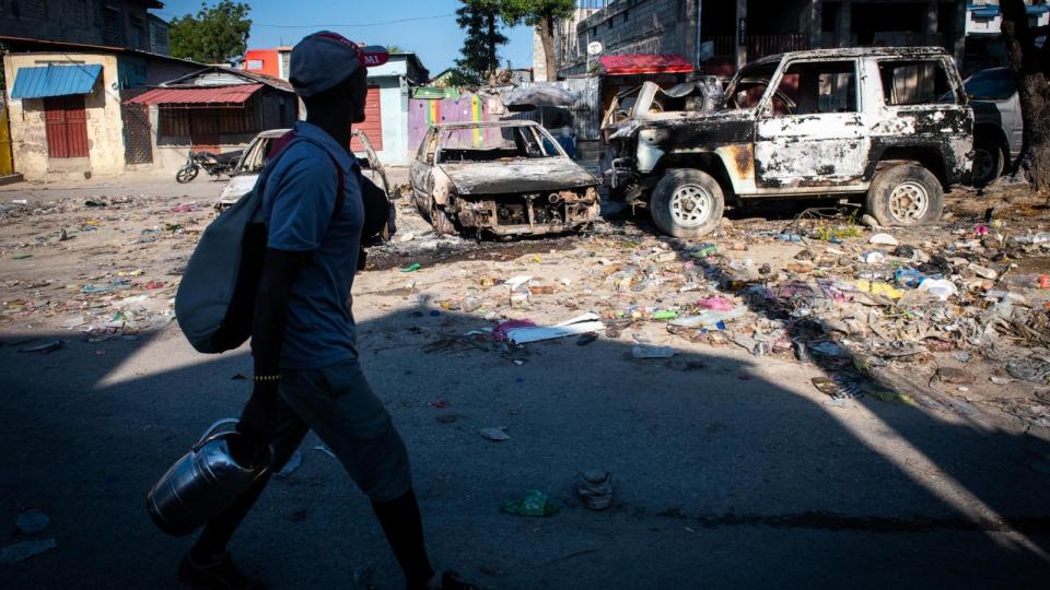 PHOTO: A man walks in front of burned vehicles due to violence in Port-au-Prince, Haiti, Mar. 9 2024.  (Johnson Sabin/EPA-EFE/Shutterstock)