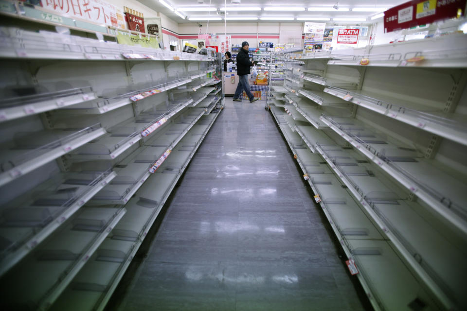 FILE - A man shops in a convenience store where shelves on food aisles are left empty in Ofunato, Iwate Prefecture, northern Japan, on March 15, 2011, four days after a powerful earthquake-triggered tsunami hit Japan's east coast. The 2011 quake, tsunami and nuclear meltdown in northern Japan provides a glimpse of what Turkey and Syria could face in the years ahead. No two events are alike, but the recent disaster resembles Japan's in the sheer enormity of the psychological trauma, of the loss of life and of the material destruction. (AP Photo/Shizuo Kambayashi, File)