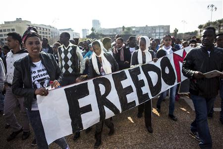 African migrants hold a sign during a protest at Rabin Square in Tel Aviv January 5, 2014. REUTERS/Nir Elias