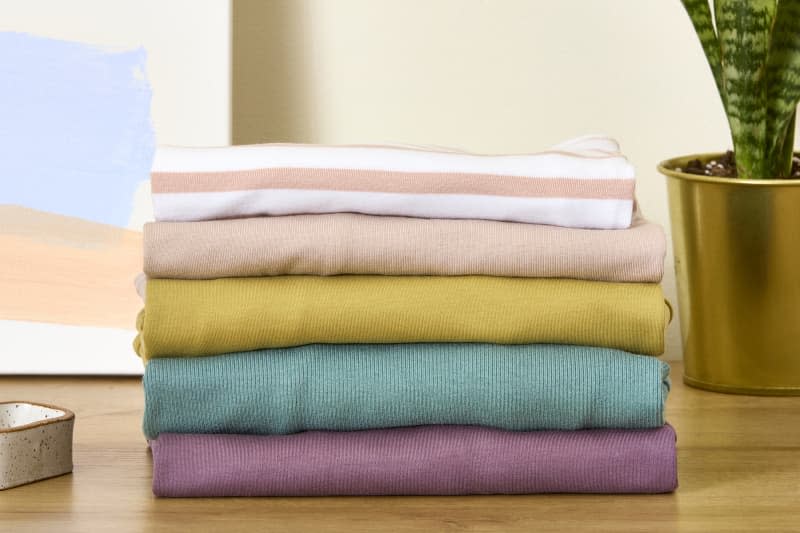 head on shot of a stack of shirts , folded on a dresser