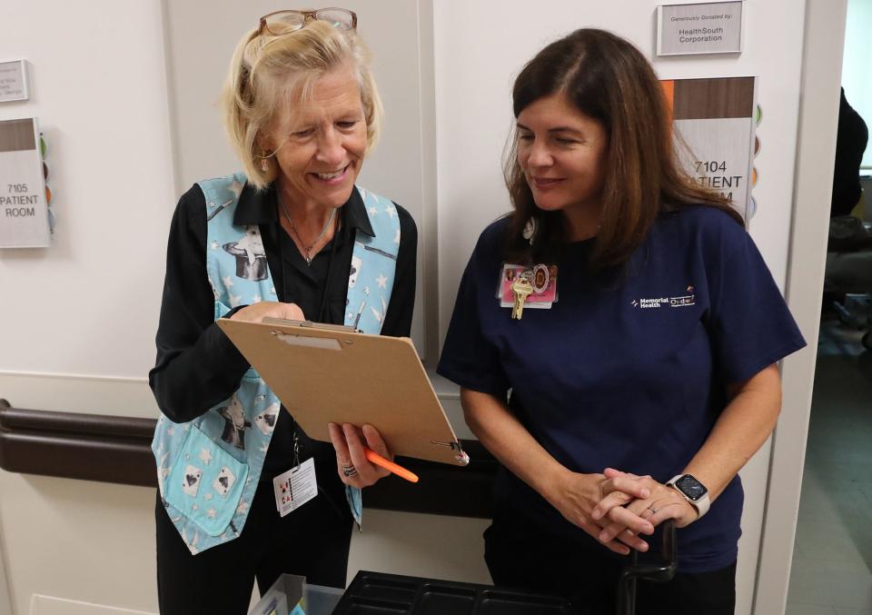 Volunteer magician Tina Kelly, left, goes over a patient list with Kristen King, manager of child life and pediatric wellness, as she visits patients at the Memorial Health Dwaine and Cynthia Willett Children’s Hospital of Savannah.
