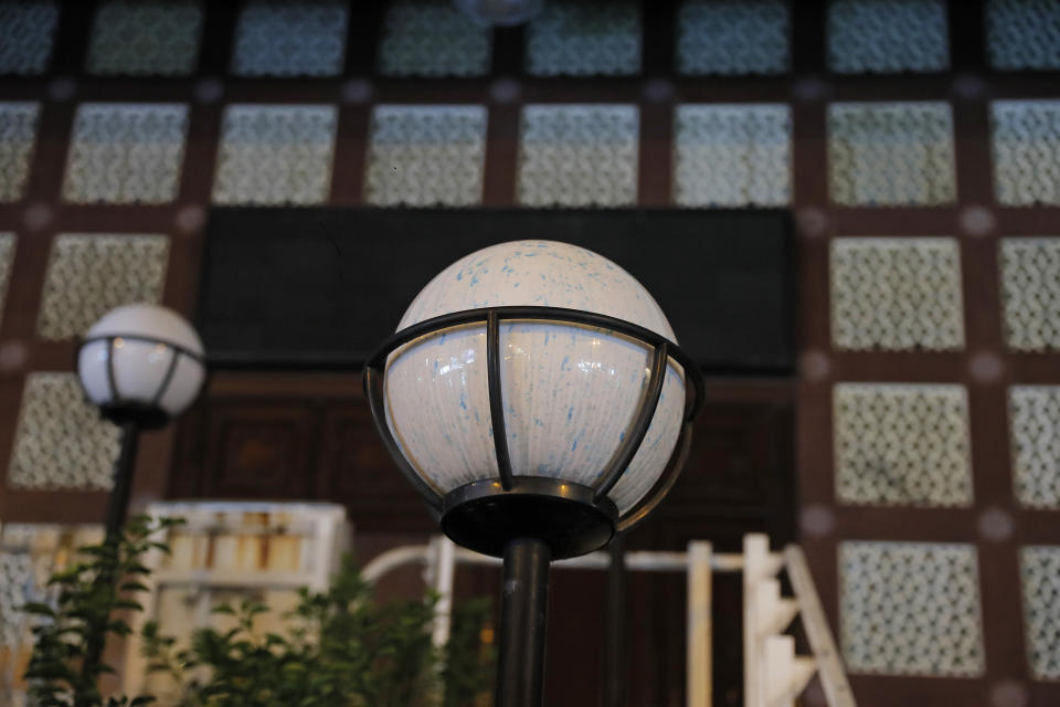 A lamp outside the mosque is sprayed by blue-dyed liquid in Hong Kong, Sunday, Oct. 20, 2019, after a water cannon truck prayed a stinging blue-dyed liquid as police moved to clear the road of protesters and barricades outside a mosque. Local broadcaster RTHK reported that the people hit were guarding the mosque and few protesters were nearby, and the Hong Kong police force said it was an "unintended impact" of its operation to disperse protesters and later sent a representative to meet the mosque's Imam. (AP Photo/Kin Cheung)