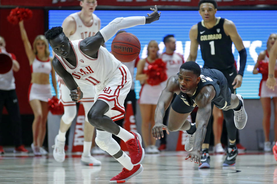 Utah guard Both Gach (11) and Colorado guard McKinley Wright IV, right, go after a loose ball in the second half during an NCAA college basketball game Saturday, March 7, 2020, in Salt Lake City. (AP Photo/Rick Bowmer)