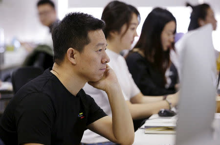 FILE PHOTO: Jia Yueting, co-founder and head of LeEco, uses a computer on a staff's seat as he poses for a photo after a Reuters interview at LeEco headquarters in Beijing, China, April 22, 2016. REUTERS/Jason Lee/File Photo