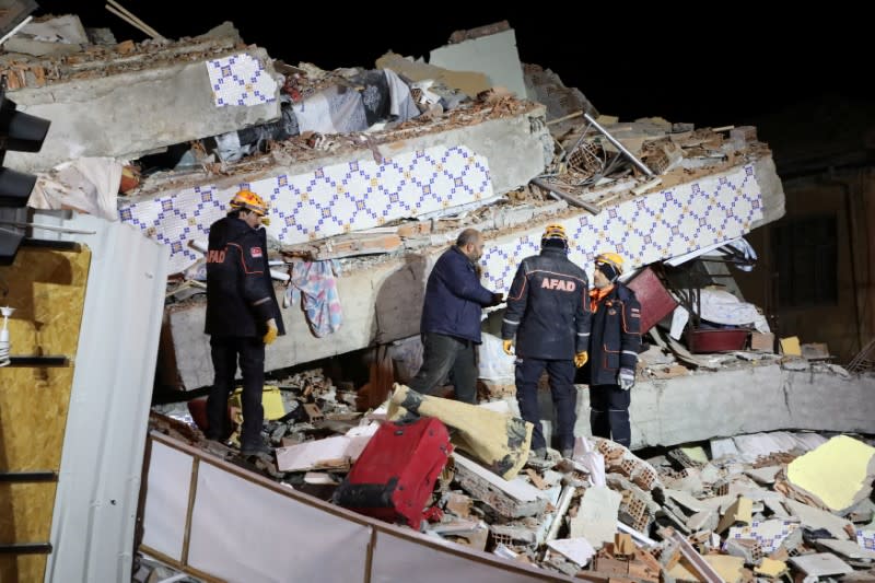 Rescue workers search on a collapsed building after an earthquake in Elazig