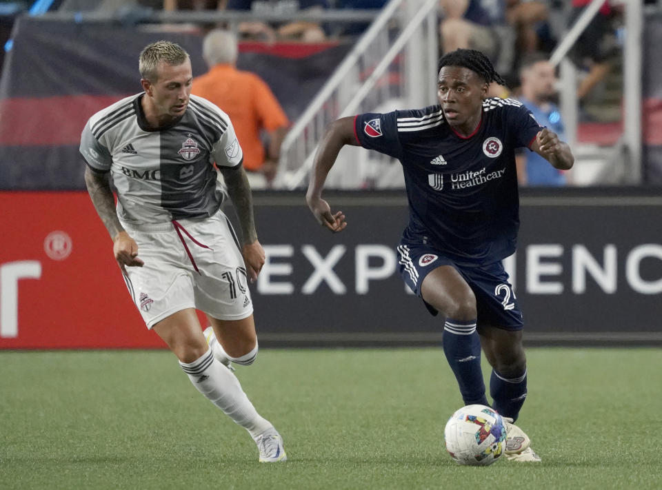 New England Revolution's DeJuan Jones dribbles the ball up the field as Toronto FC's Federico Bernardeschi (10) tries to defend during the second half of an MLS soccer match Saturday, July 30, 2022, in Foxborough, Mass. (AP Photo/Mary Schwalm)