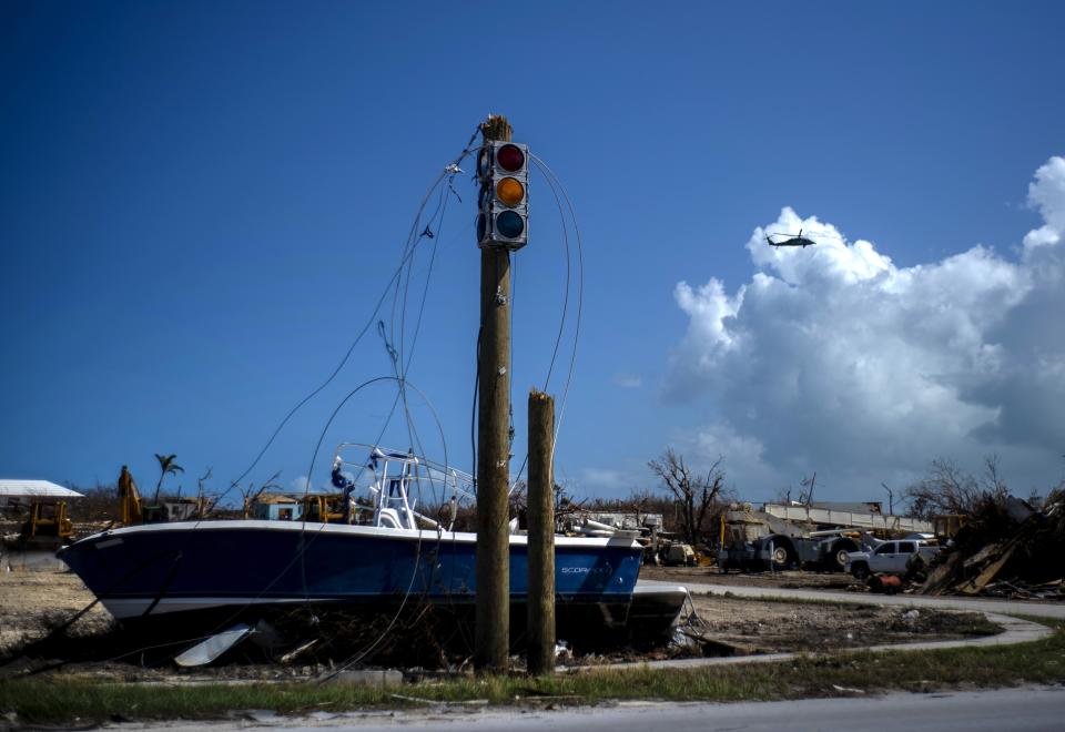 A boat sits on dry land next to a traffic light in the aftermath of Hurricane Dorian, in Abaco, Bahamas, Tuesday Sept. 17, 2019. Dorian hit the northern Bahamas on Sept. 1, with sustained winds of 185 mph (295 kph), unleashing flooding that reached up to 25 feet (8 meters) in some areas. (AP Photo/Ramon Espinosa)