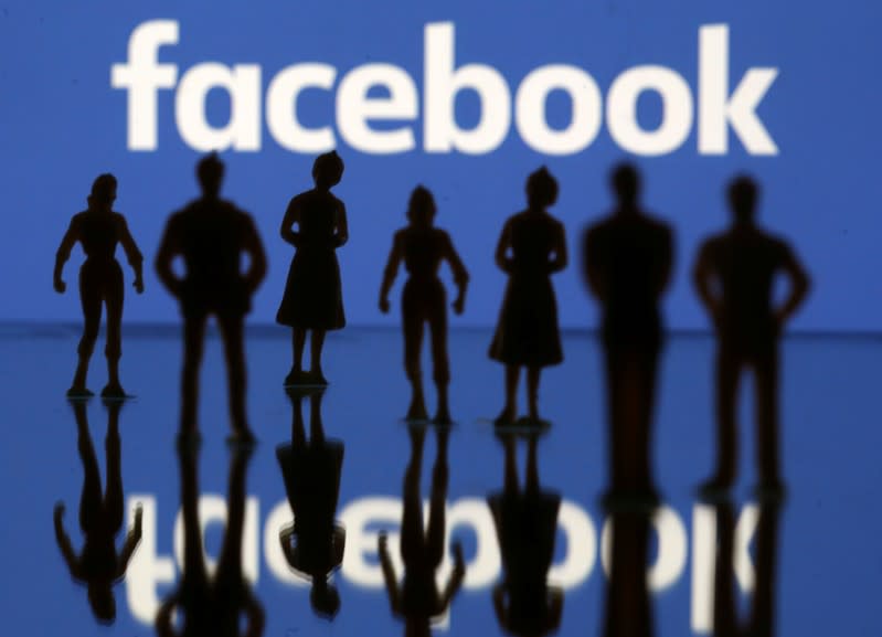 Small toy figures are seen in front of Facebook logo in this illustration picture