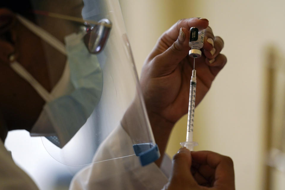 FILE - In this Tuesday, Jan. 12, 2021 photo, a pharmacist with Walgreens Pharmacy prepares a syringe with the Pfizer-BioNTech COVID-19 vaccine for residents and staff at the The Palace assisted living facility in Coral Gables, Fla. Florida was one of the first states to throw open vaccine eligibility to members of the general public over 65, leading to rumors that tourists and day-trippers are swooping into the state solely for the jab. Gov. Ron DeSantis said stories of the rich flying to Florida, getting vaccinated and returning home are overblown. (AP Photo/Lynne Sladky, File)