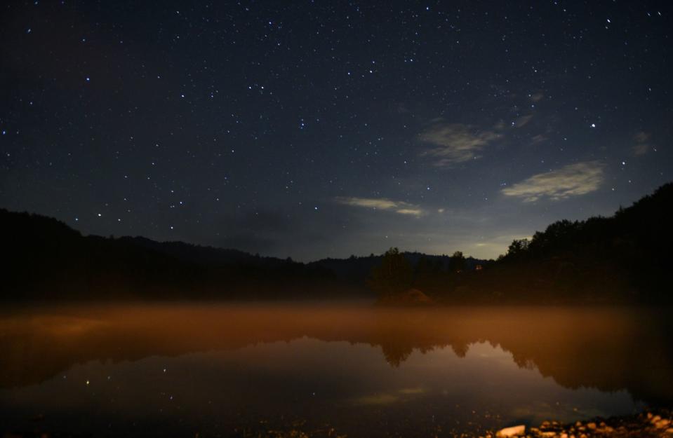 <p>A starry sky glows over a misty mountain lake in Bize, Albania // August 04, 2018</p>