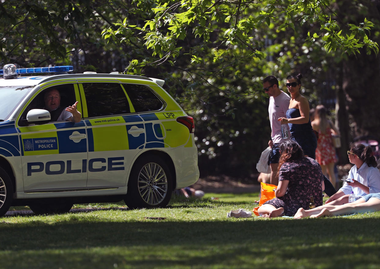 Police officers in a patrol car move sunbathers on in Greenwich Park, London, as the UK continues in lockdown to help curb the spread of the coronavirus.