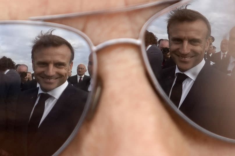 Le président français Emmanuel Macron se reflète dans les lunettes d'un habitant après une cérémonie, mardi 18 juin 2024 sur l'Île de Sein, en Bretagne. 