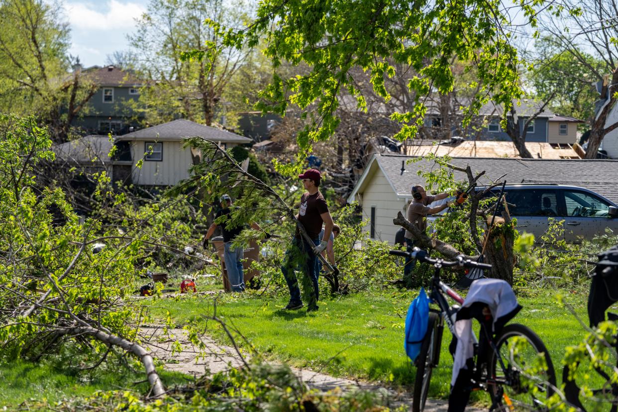 Residents clean up debris in Pleasant Hill, Saturday, April 27, 2024, after multiple tornados ripped across the state Friday evening.