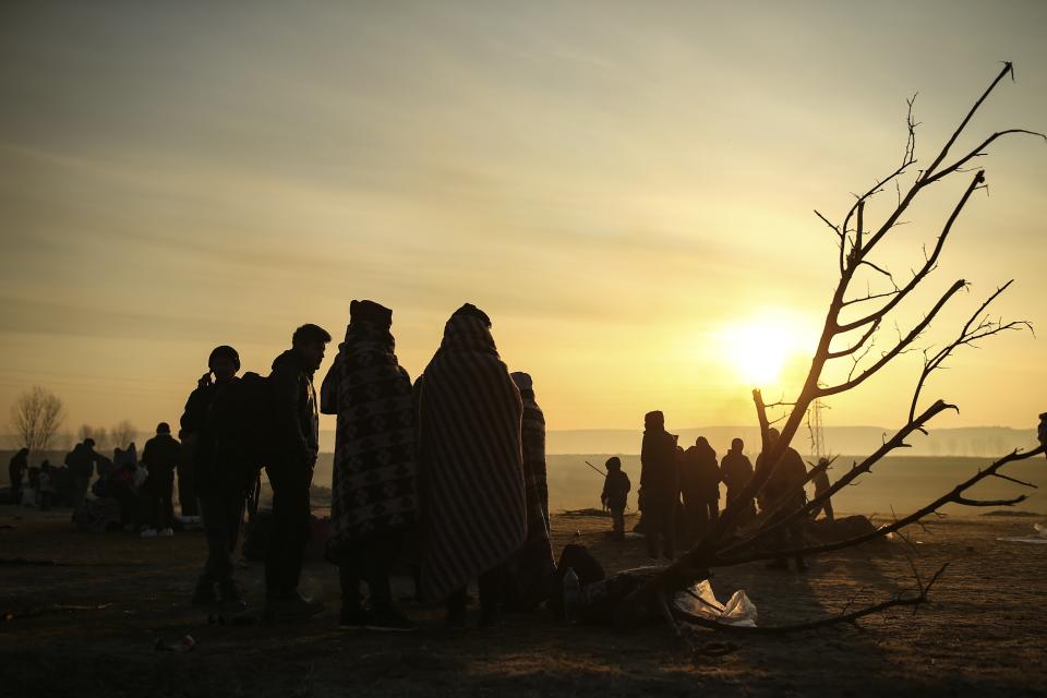 Migrants gather at Maritsa river (Evros river in Greek) near the Pazarkule border gate in Edirne, Turkey, Sunday, March 1, 2020. The United Nations migration organization said Sunday that at least 13,000 people were massed on Turkey's land border with Greece, after Turkey officially declared its western borders were open to migrants and refugees hoping to head into the European Union. (AP Photo/Emrah Gurel)