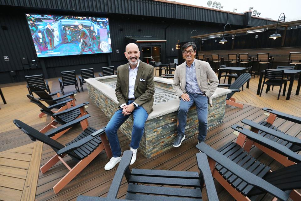 Partners Andre Carrier, left, and Greg Lee pose on the brand new deck at The Brook in Seabrook.