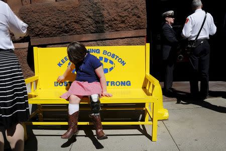 Jane, the sister of Boston Marathon bombing victim Martin Richard, sits on a new bench with the words "Keep Running Boston" and "Boston Strong" on it outside the fire station on Boylston Street on the second anniversary of the Boston Marathon bombings in Boston, Massachusetts April 15, 2015. REUTERS/Brian Snyder