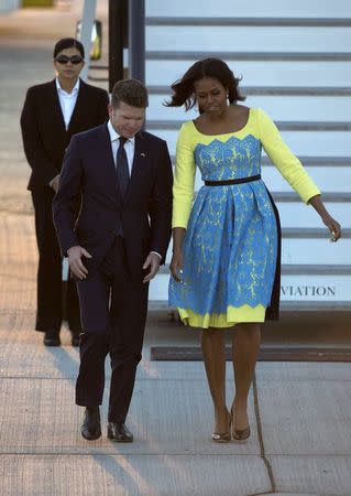 U.S. first lady Michelle Obama greets U.S. Ambassador to Britain Matthew Barzun (L) at Stansted Airport, southern England June 15, 2015. REUTERS/Neil Hall