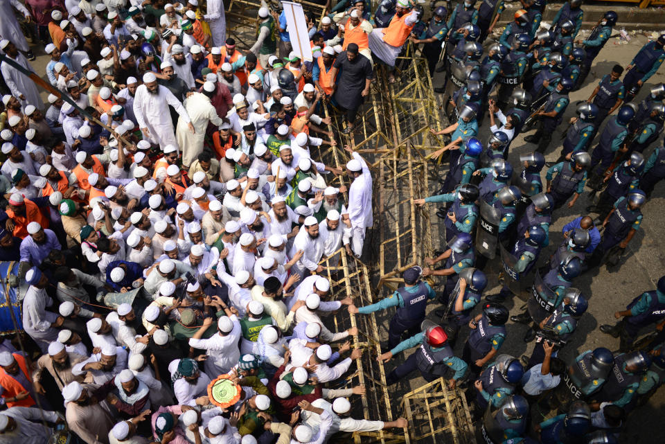 Supporters of Islami Andolan Bangladesh, an Islamist political party, face a barrier during a protest against French President Emmanuel Macron and against the publishing of caricatures of the Prophet Muhammad they deem blasphemous, in Dhaka, Bangladesh, Tuesday, Oct. 27, 2020. Muslims in the Middle East and beyond on Monday called for boycotts of French products and for protests over the caricatures, but Macron has vowed his country will not back down from its secular ideals and defense of free speech. (AP Photo/Mahmud Hossain Opu)