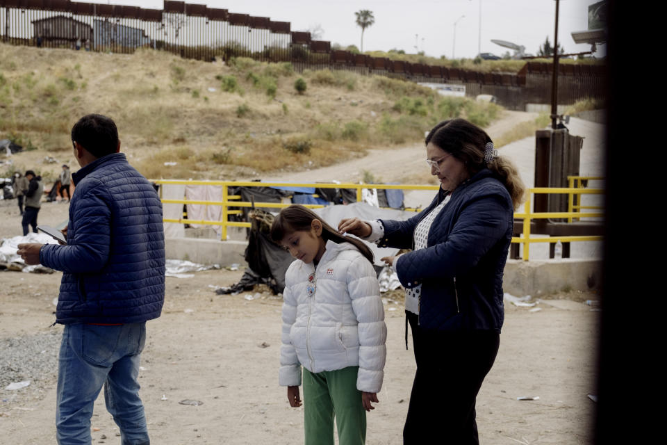 Una madre colombiana cepilla el cabello de su hija dentro del campamento de migrantes. (Mark Abramson/The New York Times)
