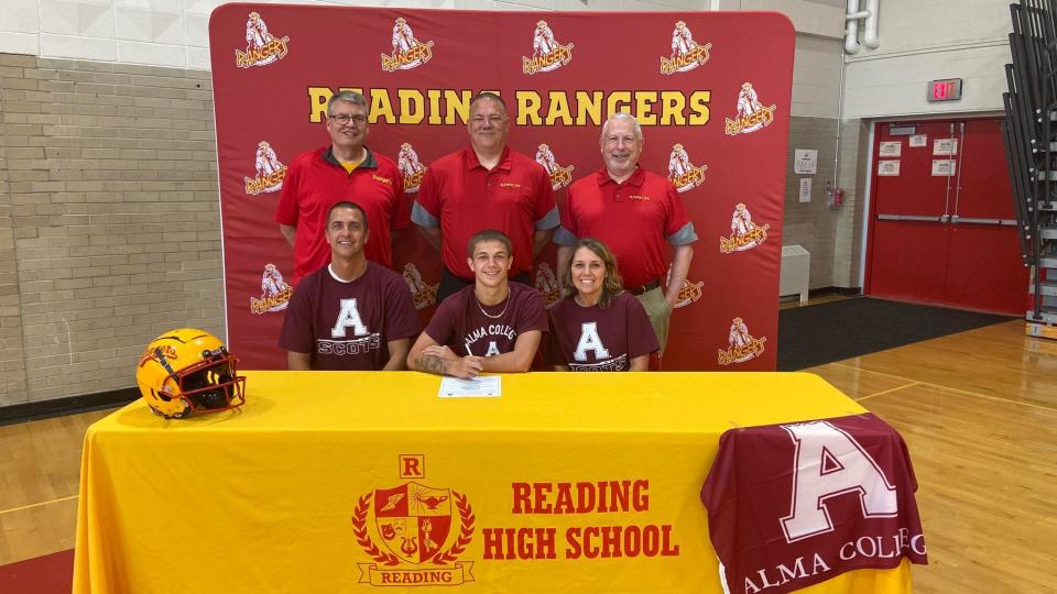 Reading graduate Jacob Hamilton, joined by his parents and football coaches, signs his letter of intent to join the Alma Scotts football team.